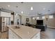 Open kitchen featuring a large island with granite countertop, stainless steel appliances, and adjacent living area at 5946 Caspian Tern Dr, Sarasota, FL 34238