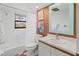 A compact bathroom featuring an updated white vanity, a tub with shower, and stylish tile accents at 6071 Fairway Ln # 1424, Bradenton, FL 34210