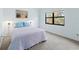 Cozy bedroom with light blue walls, soft carpet, and sconce lighting at 6071 Fairway Ln # 1424, Bradenton, FL 34210