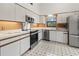 Well-lit kitchen featuring white cabinets, stainless steel appliances, and mosaic tile flooring at 6071 Fairway Ln # 1424, Bradenton, FL 34210