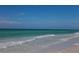 Waves gently breaking on the shore of this beautiful sandy beach with clear, turquoise water at 6140 Midnight Pass Rd # B6, Sarasota, FL 34242