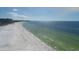 Expansive beach view from above, showing white sand, clear water, and buildings in the distance at 6140 Midnight Pass Rd # B6, Sarasota, FL 34242