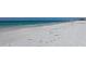 Stunning beach view with white sand, turquoise waters, and footprints in the sand at 6140 Midnight Pass Rd # B6, Sarasota, FL 34242