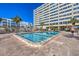Enjoy the sparkling pool surrounded by pavers, with views of the building and palm trees under a clear blue sky at 6140 Midnight Pass Rd # B6, Sarasota, FL 34242