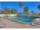 A refreshing community pool with lounge chairs, tables and clear blue skies at 6140 Midnight Pass Rd # B6, Sarasota, FL 34242