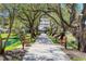 Picturesque walkway framed by mature trees and lush landscaping, leading to building entrance at 6285 Midnight Pass Rd # 101, Sarasota, FL 34242