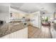 Bright kitchen featuring granite countertops, white cabinets, tile flooring, and modern appliances at 6537 Gulf Of Mexico Dr, Longboat Key, FL 34228