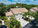 Aerial view of home's exterior showcasing lush landscaping, tile roof, and multiple car garage at 6726 Fairview Ter # 6726, Bradenton, FL 34203