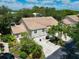 Aerial view of home's exterior showcasing lush landscaping, tile roof, and multiple car garage at 6726 Fairview Ter # 6726, Bradenton, FL 34203