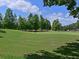 Scenic golf course view with lush green grass, mature trees, and a clear blue sky with scattered clouds at 6726 Fairview Ter # 6726, Bradenton, FL 34203