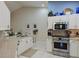 Kitchen boasts white cabinets, granite countertops, and stainless steel appliances at 6726 Fairview Ter # 6726, Bradenton, FL 34203