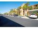 Exterior view showcasing the condo building with palm trees and covered parking at 8403 Grand Estuary Trl # 208, Bradenton, FL 34212