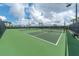 Beautiful tennis courts under a partly cloudy sky and surrounded by mature landscaping at 8403 Grand Estuary Trl # 208, Bradenton, FL 34212