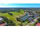 Aerial view of the community showing a golf course, tennis courts, pool, and clubhouse at 8755 Olde Hickory Ave # 7204, Sarasota, FL 34238