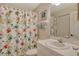 Bathroom with white vanity, toilet and whimsical shower curtain at 8755 Olde Hickory Ave # 7204, Sarasota, FL 34238