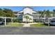 Well-maintained condo building featuring lush landscaping, covered parking, and sidewalks at 8755 Olde Hickory Ave # 7204, Sarasota, FL 34238