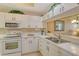 Modern kitchen featuring white cabinetry, a breakfast bar, and views to the dining area at 8755 Olde Hickory Ave # 7204, Sarasota, FL 34238