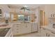 Charming kitchen featuring white cabinets, matching appliances and a pass-through to the living area at 8755 Olde Hickory Ave # 7204, Sarasota, FL 34238