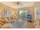 Cozy living room with comfortable seating, a ceiling fan, and a sliding door to the lanai at 8755 Olde Hickory Ave # 7204, Sarasota, FL 34238