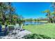 Relax outdoors by the pond with table and chairs to appreciate beautiful sunny views at 8755 Olde Hickory Ave # 7204, Sarasota, FL 34238