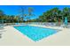 Enjoy the clear blue community pool with lounge chairs for relaxation under the sunny skies at 8755 Olde Hickory Ave # 7204, Sarasota, FL 34238