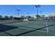 View of green tennis courts with lighting and covered seating area at 8755 Olde Hickory Ave # 7204, Sarasota, FL 34238