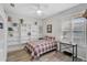Cozy bedroom boasts a full bookcase, natural light, and a comfortable plaid bedspread at 10030 Reagan Dairy Trl, Bradenton, FL 34212