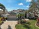 Beautiful home with a well-manicured lawn, mature trees, lush landscaping, and a brick-paved driveway at 10030 Reagan Dairy Trl, Bradenton, FL 34212