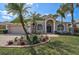 Beautiful home featuring a well-manicured lawn and mature palm trees, plus an attractive, arched entry at 10030 Reagan Dairy Trl, Bradenton, FL 34212