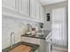 Convenient laundry room with storage cabinets, countertop space, sink, and a window for natural light at 10030 Reagan Dairy Trl, Bradenton, FL 34212