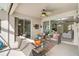 Inviting covered patio featuring comfortable wicker furniture, ceiling fan, and multiple access points at 10030 Reagan Dairy Trl, Bradenton, FL 34212