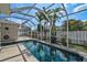 A beautiful screened-in pool area surrounded by lush landscaping and ample space for outdoor seating and relaxation at 10030 Reagan Dairy Trl, Bradenton, FL 34212