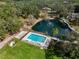 Aerial view showcases a luxurious pool, pond with fountain, and lush landscaping at 1228 Wagon Wheel Dr, Sarasota, FL 34240