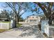 A long concrete driveway leads to the impressive three-car garage with mature trees and gated entrance at 1228 Wagon Wheel Dr, Sarasota, FL 34240