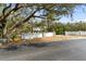 Gated entrance to property featuring mature trees and a secure, private perimeter wall at 1228 Wagon Wheel Dr, Sarasota, FL 34240