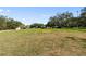 Expansive lawn area with mature trees and white umbrellas, providing a serene outdoor space at 1228 Wagon Wheel Dr, Sarasota, FL 34240