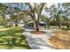 Scenic exterior view of the clubhouse with surrounding trees and concrete walkway at 1228 Wagon Wheel Dr, Sarasota, FL 34240