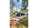 Side exterior view of the clubhouse with patio seating, and surrounding landscape at 1228 Wagon Wheel Dr, Sarasota, FL 34240