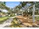 Community playground with swings, slides, picnic tables, and a lush, green lawn at 1228 Wagon Wheel Dr, Sarasota, FL 34240
