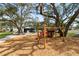 Playground with slides and climbing structure in a green, tree-filled community at 1228 Wagon Wheel Dr, Sarasota, FL 34240