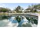 Scenic view of a pond with fountain and pier, surrounded by lush landscaping at 1228 Wagon Wheel Dr, Sarasota, FL 34240
