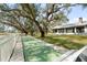 Shuffleboard court surrounded by mature trees and a manicured lawn, perfect for outdoor recreation at 1228 Wagon Wheel Dr, Sarasota, FL 34240