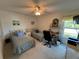 Bright bedroom featuring two twin beds, a ceiling fan, and a window overlooking a serene landscape at 1321 Glendale E Cir # 909, Sarasota, FL 34232