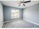 Bedroom with a large window providing natural light and gray carpeting at 13227 Prestwick Creek Dr, Riverview, FL 33579