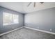 This bedroom features a ceiling fan, window, and plush grey carpeting at 13227 Prestwick Creek Dr, Riverview, FL 33579