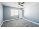 Cozy bedroom with fresh grey paint, plush carpet, window and a ceiling fan at 13227 Prestwick Creek Dr, Riverview, FL 33579