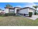 Charming single-story home with well-maintained front yard and attached garage, situated under a clear, sunny sky at 13227 Prestwick Creek Dr, Riverview, FL 33579