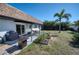 Spacious backyard with a patio, grill, outdoor seating, and a well-maintained lawn with a palm tree at 13575 Martha Ave, Port Charlotte, FL 33981