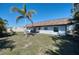 Exterior backyard view showcases a spacious lawn, palm trees, patio and a relaxing outdoor setting at 13575 Martha Ave, Port Charlotte, FL 33981