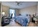 Cozy bedroom with wood-look tile flooring, a comfortable bed with blue accents, and a functional desk area at 13575 Martha Ave, Port Charlotte, FL 33981